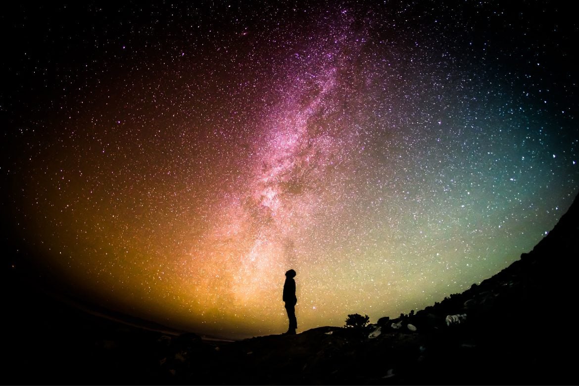 A person looking up at the Milky Way in the night sky. 