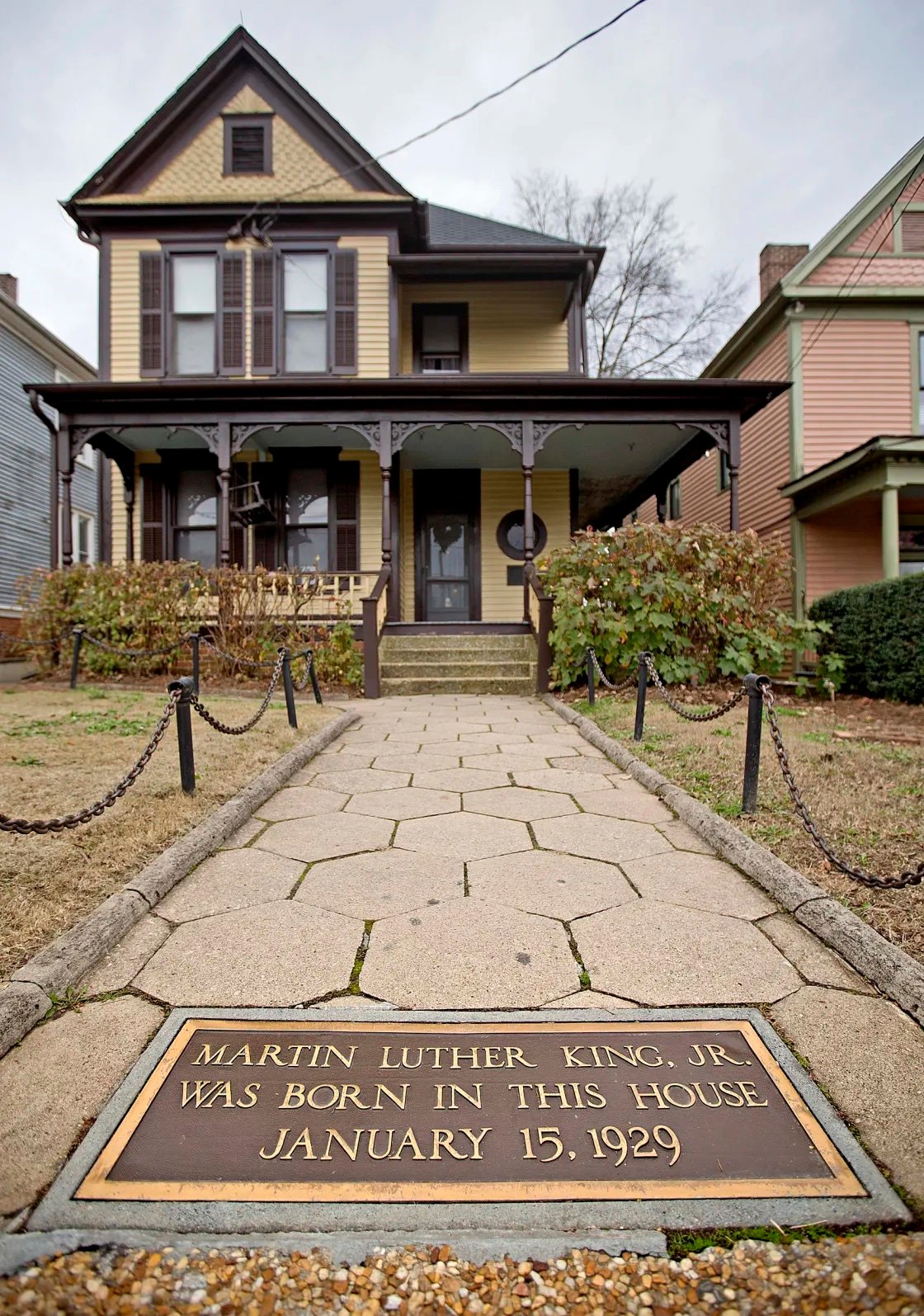 A photograph of the birth home of Martin Luther King Jr., with a memorial plaque embedded in the walkway